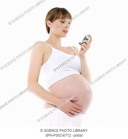 Asthmatic pregnant woman. 36 weeks pregnant woman using an asthma inhaler