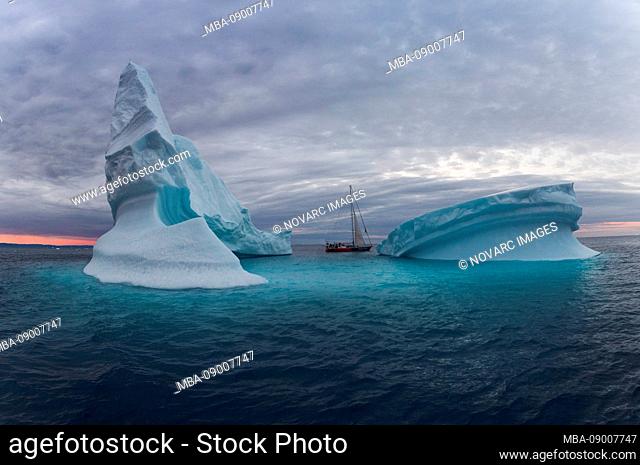 Icebergs and sailboat in Disko Bay on Midsummer, Greenland