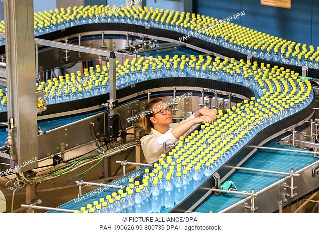 24 June 2019, Saxony, Eilenburg: An employee monitors the filling of Ileburger mineral water with lemon taste at Sachsenquelle GmbH