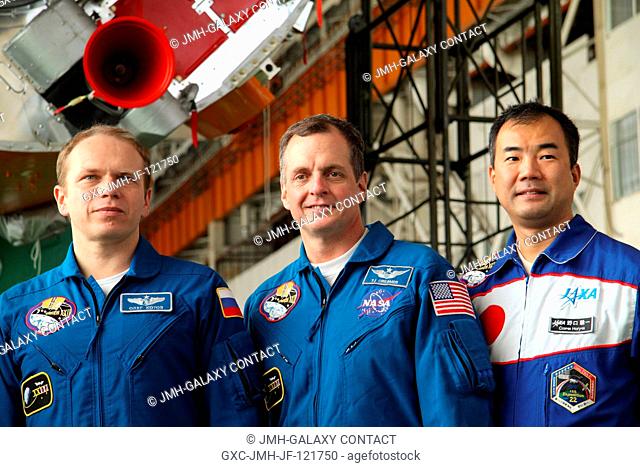 The Expedition 22 crew poses for a group snapshot while visiting the Soyuz launch vehicle assembly facility in front of the rocket's third stage