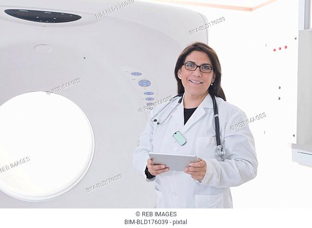 Hispanic doctor standing in MRI room