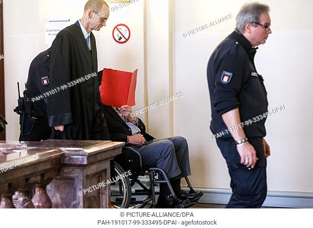 17 October 2019, Hamburg: A 93-year-old former SS guard of the Stutthof concentration camp near Gdansk is pushed out of the courtroom by a court official...