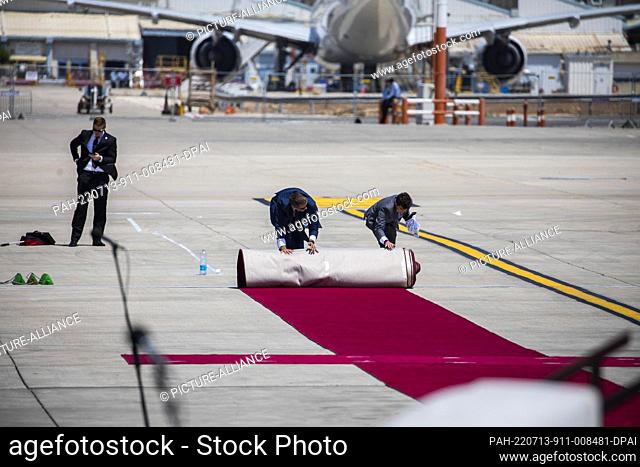 13 July 2022, Israel, Lod: Workers unfurl a red carpet at Ben Gurion Airport ahead of the arrival of US President Joe Biden for the state visit to Israel