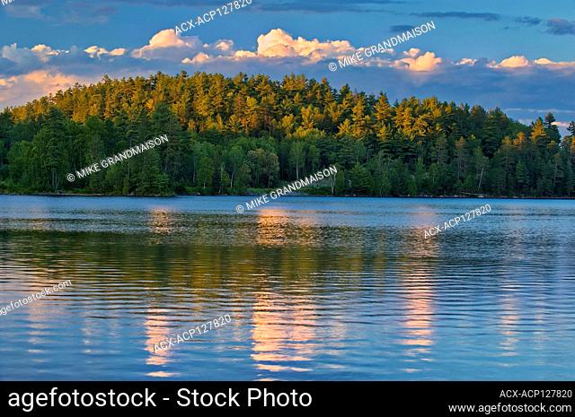 Clouds reflected in Snake Island Lake at sunset. The White Bear Forest Conservation Reserve Temagami Ontario Canada
