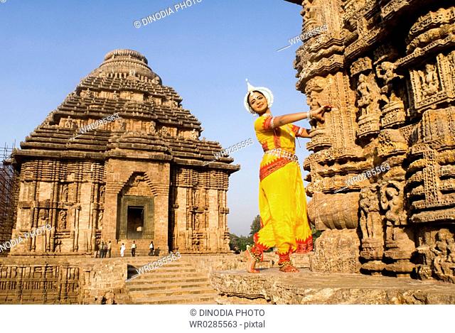 Odissi dancer strike pose re-enacts Indian myths such as Ramayana in front of world heritage Sun temple complex in Konarak , Orissa , India MR400