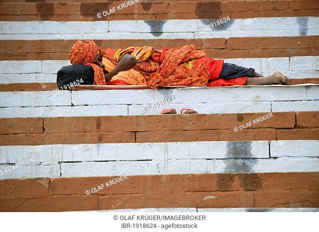 Sadhu or holy man sleeping on the sacred stairs or Ghats, Varanasi, Ganges, Uttar Pradesh, India, Asia