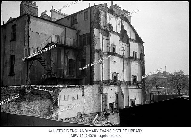 A view of a range of Eldon Square being demolished, possibly the west range, seen from the rear, with a partial view of the square in the background and showing...