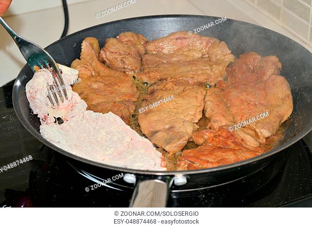 cooking meat in a pan on an induction plate