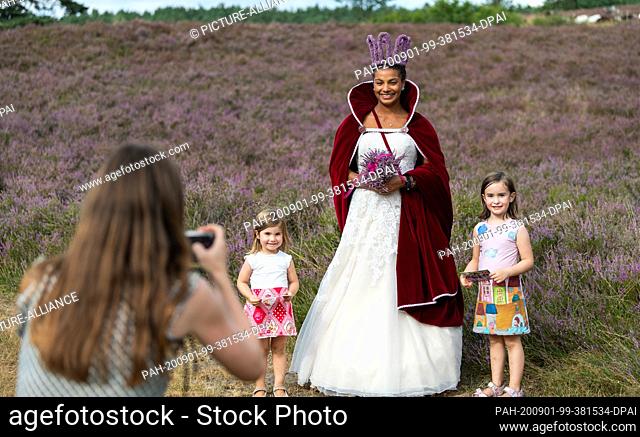 21 August 2020, Lower Saxony, Amelinghausen: Leonie Laryea (M), queen of the heath, is photographed together with Asmara (l) and Julila (r) in the heath