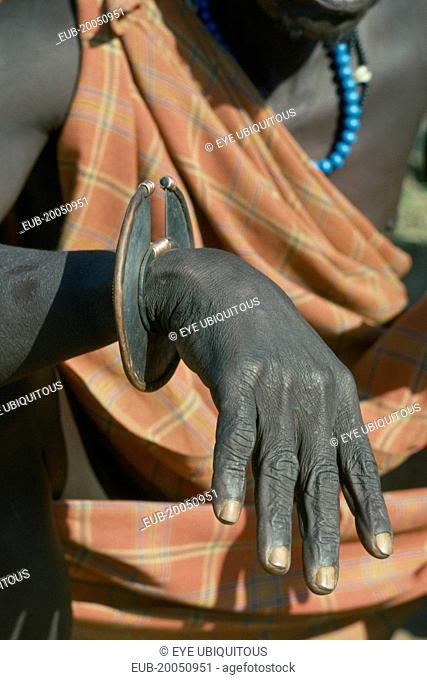 Cropped shot of Karamojong Dodoth warrior displaying wrist knife used for cutting meat and as a weapon before the use of guns