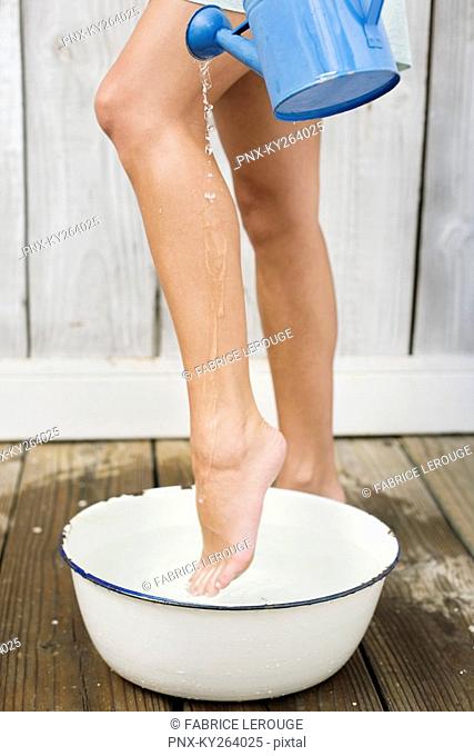 Woman washing legs in the bathroom
