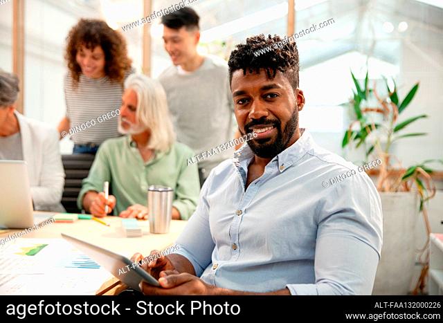 African American businessman using digital tablet while looking at the camera