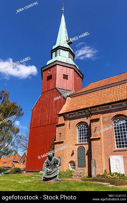 Next to the church St. Martin et Nicolai stands the bronze figure of priest Heinrich, by sculptor Carsten Eggers in Steinkirchen, Altes Land, district of Stade