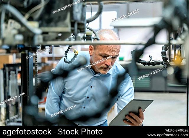 Businessman using tablet in a factory