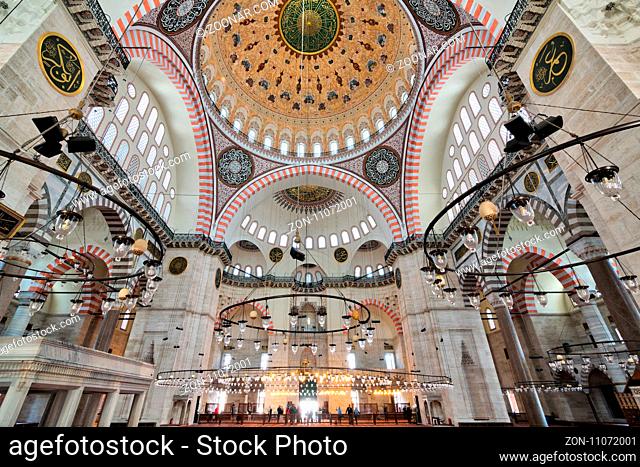 Istanbul, Turkey - April 19, 2017: Interior of Suleymaniye Mosque, with a huge pillars, arches, windows and tourists visiting the mosque, Istanbul, Turkey