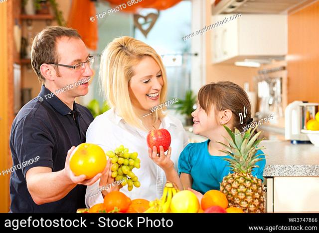 Family (mother, father and child) with lots of fruits for breakfast food, this is healthy nutrition
