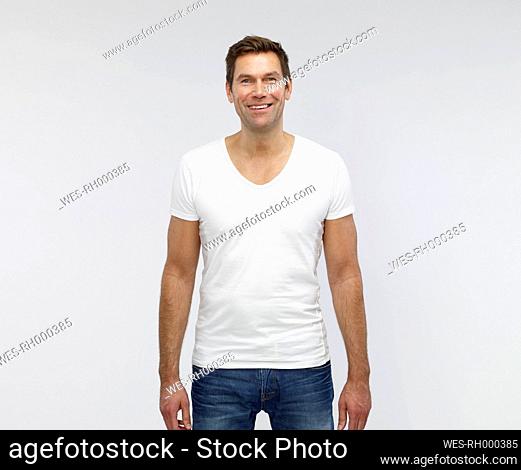 Portrait of smiling mature man in front of white background