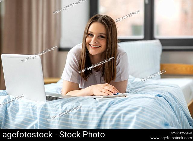 teenage student girl with laptop learning at home