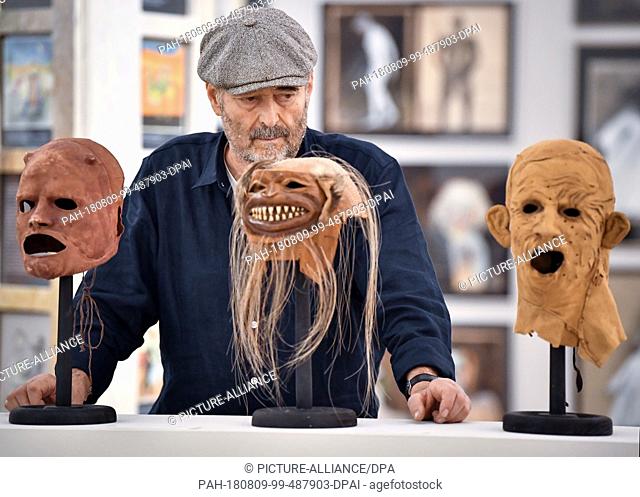 FILED - 18 July 2018, Germany, Neuhardenberg: The make-up artist Wolfgang Utzt stands behind his masks in an exhibition hall of the Brandenburg Art Prize of the...