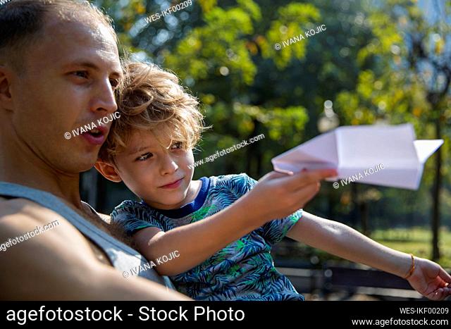 Father with son playing with paper airplane
