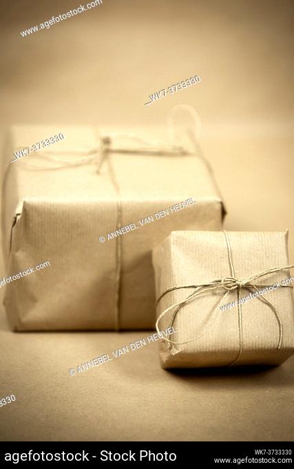 two gift package wrapped with plain brown paper and rope and brown paper background texture, retro gift box. present concept copy space