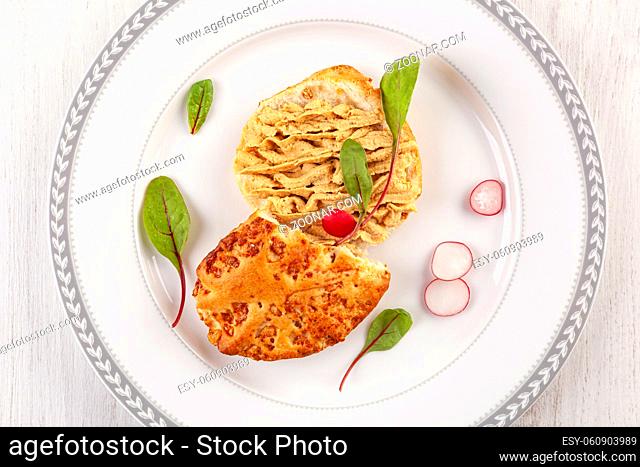 Vegetable spread on bread with radish on white plate from above