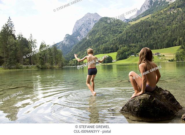 Brother and sister playing in lake, Hintersee, Zauberwald, Bavaria, Germany