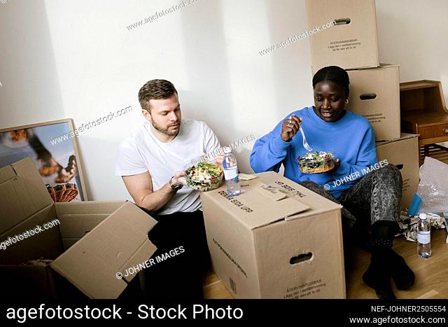 Couple having meal while moving house