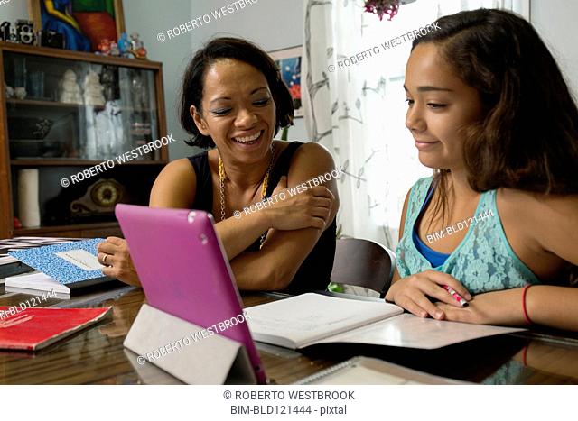 Mixed race mother helping daughter with homework