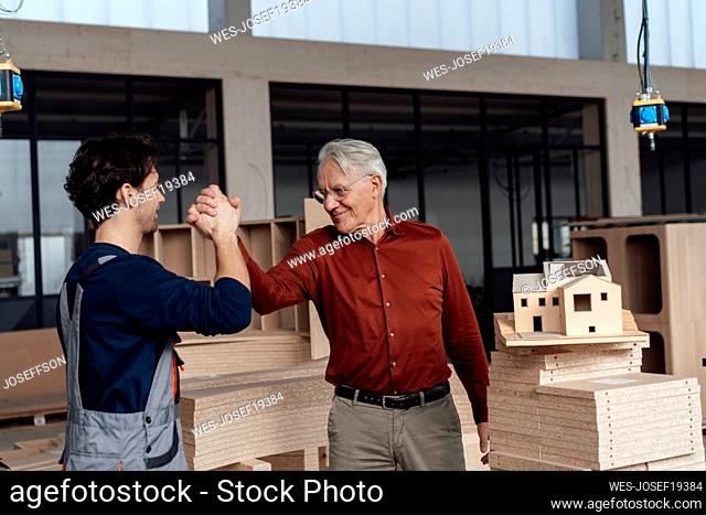 Businessman with colleague giving high-five to each other