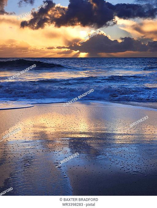 Early morning light glistening on the wet sand with dramatic clouds beyond, Porthcurno, Cornwall, England, United Kingdom, Europe