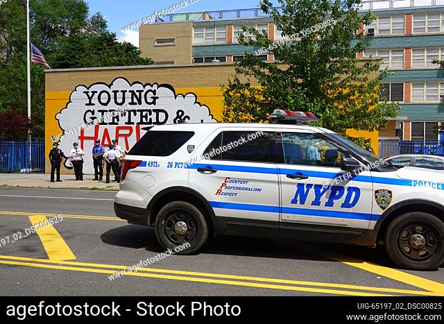 Police officers attend the Harlem Families Black Lives Matter march outside P.S. 180 in Harlem, New York City