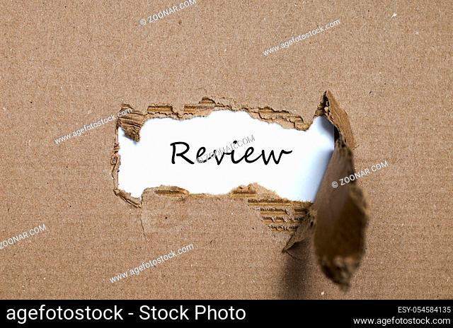 The word review appearing behind torn paper