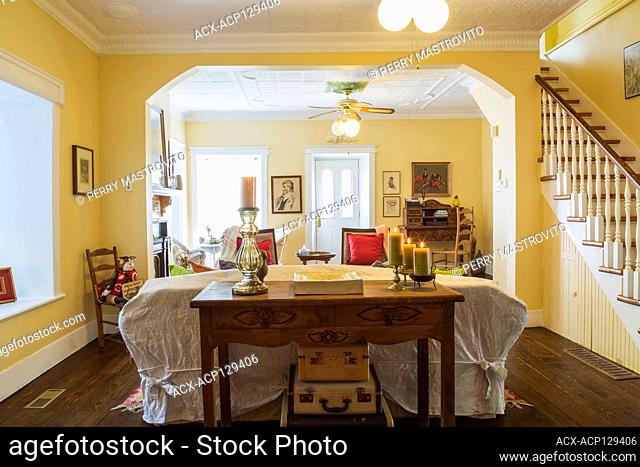 Antique wooden console table, sofa, Eclectic chairs and secretary desk woven seat high back chair in living room inside an old circa 1830 Quebecois style...