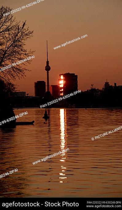 22 March 2022, Berlin: The light of the setting sun is reflected in a glass facade not far from the TV tower. Photo: Paul Zinken/dpa