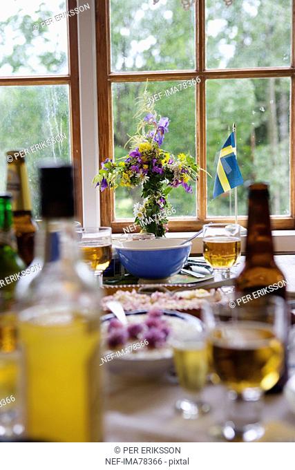 Dinner setting on table with Swedish flag and flower vase