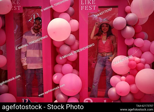 RUSSIA, MOSCOW - SEPTIEMBRE 14, 2023: La gente posa para una fotografía en una cabina de fotos de la caja de Barbie en el estreno de Moscú de la película de...
