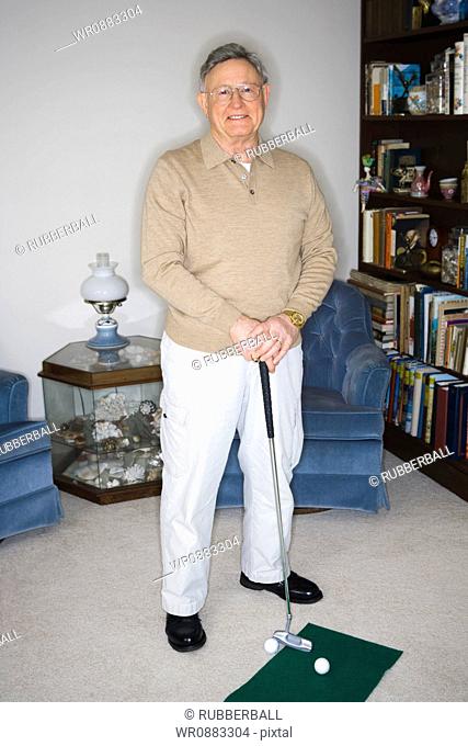 Portrait of a senior man holding a golf club