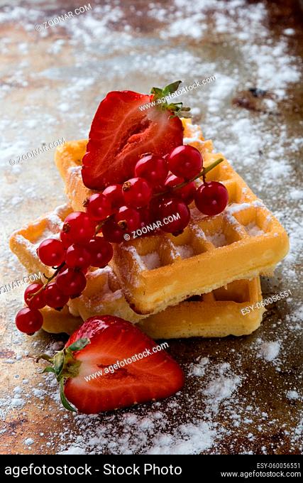 baked waffle with fruits on sugary steel plate