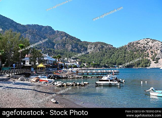 09 August 2021, Turkey, Marmaris: The small port of the tourist resort in the province of Mugla. Residents of the village have been fighting the flames in the...