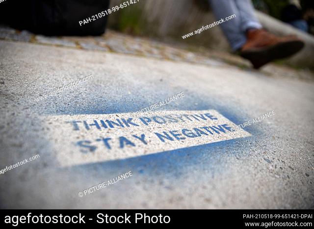 18 May 2021, Bavaria, Nuremberg: ""Think positive - Stay negative"" is spray-painted on a downtown stone. Photo: Daniel Karmann/dpa