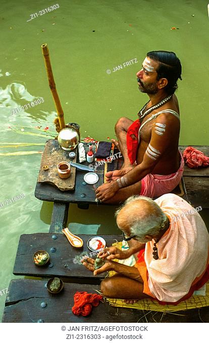 praying men at Ganga riverbank in varanasi, india