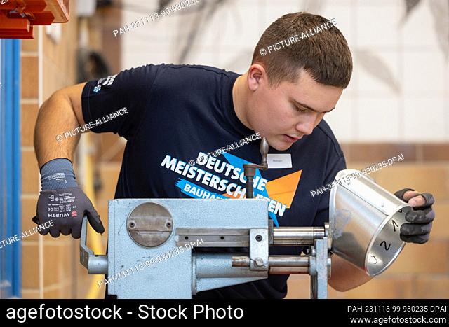 13 November 2023, Thuringia, Erfurt: Heat, cold and sound insulator Kenny Metzger is welding a nozzle for a technical system at the German Building Trade...