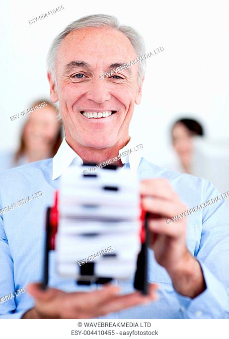 Smiling businessman consulting a business card holder