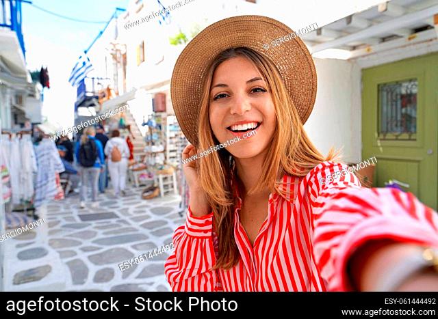 Self portrait of young woman with white smile strolling in Mykonos, Greece