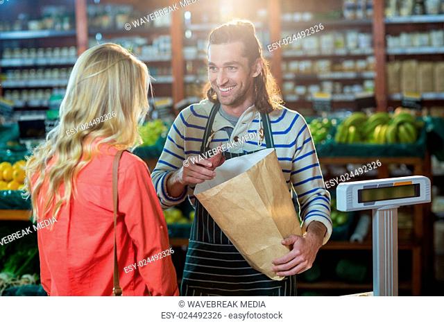 Man assisting woman in selecting vegetables