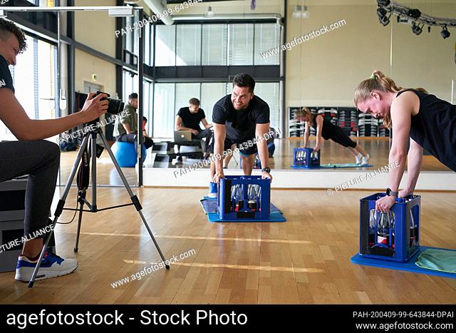 27 March 2020, Rhineland-Palatinate, Koblenz: Trainers from the Dany gym record training videos for their members, which during the corona crisis should make it...