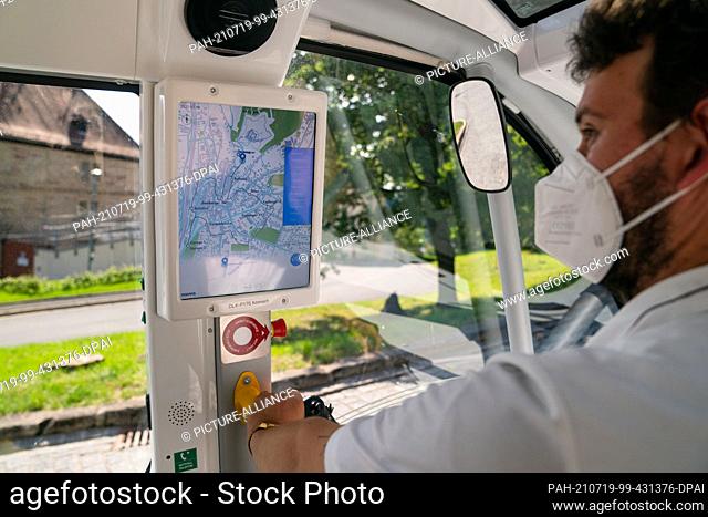 PRODUCTION - 10 July 2021, Bavaria, Kronach: Operator Brian Möller controls the display of the autonomous bus from the manufacturer Navya
