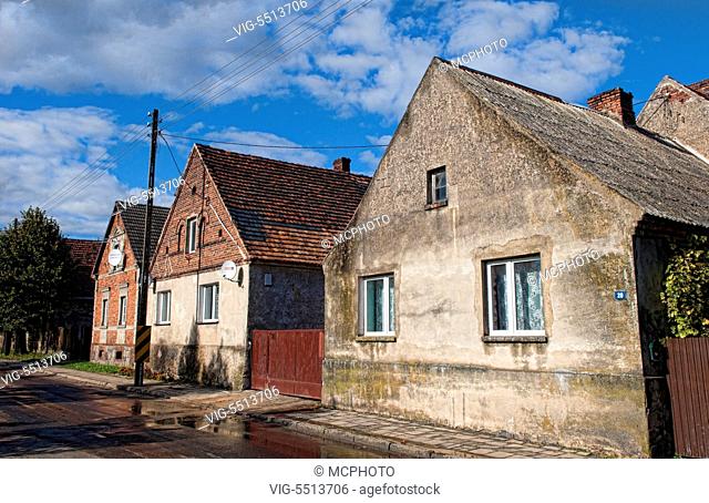 Village of Poznan Poland houses on main street of local worn buildings in sunshine - 29/09/2015