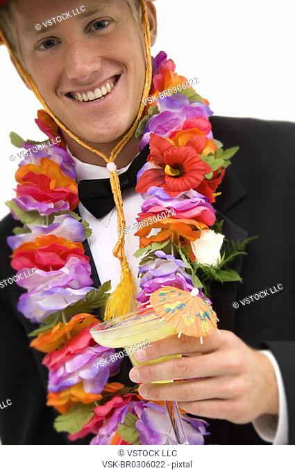 Man wearing a sombrero and flower lei and drinking a margarita